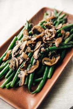 green beans and mushrooms on a brown plate