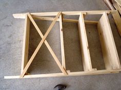 the wooden frame is being built with two pieces of plywood and a hammer on the floor