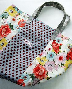 a flowered purse with polka dots and flowers on it, sitting on a white surface