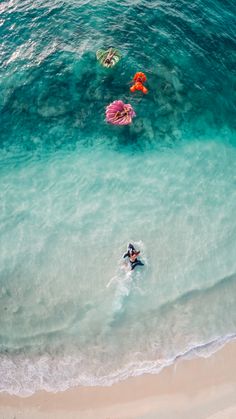 three people are swimming in the ocean with their surfboards and floaties on them