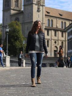 a woman walking down the street in front of a church