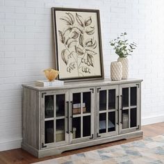 an entertainment center with glass doors on the front and bottom, in a living room