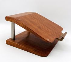 a wooden object with metal legs on a white background, it appears to be an upside down shelf