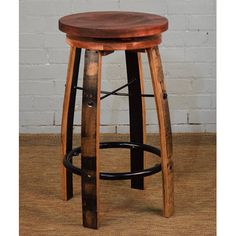 a wooden stool sitting on top of a floor next to a white brick wall in a room