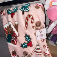 a pink christmas blanket with gingerbreads and candy canes