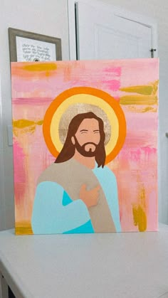 a painting of jesus holding the cross on top of a table