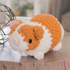 a crocheted hamster sitting on top of a table next to a wire sculpture