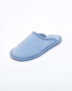 a blue slipper is laying on the white surface and it's made out of felt