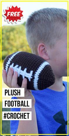 a young boy holding up a crocheted football