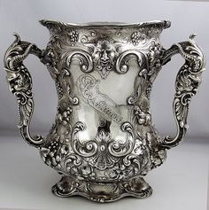 an ornate silver vase is on display against a white background