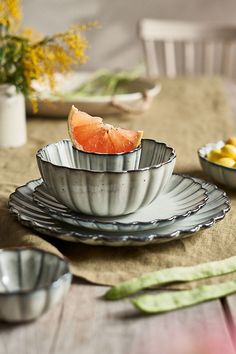 a table topped with plates and bowls filled with fruit