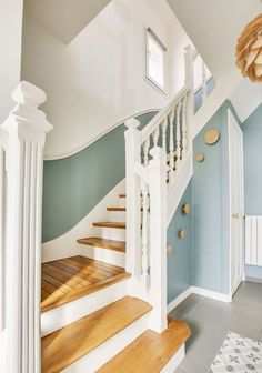 a white staircase with blue walls and wooden steps