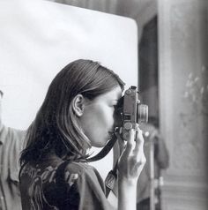 a woman holding a camera up to her face