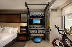 a bedroom with a bed, bike and television