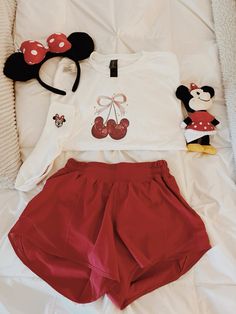 a minnie mouse shirt and shorts are laying on a bed