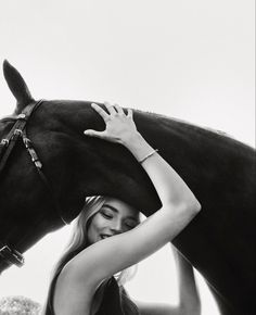 black and white photograph of a woman hugging a horse's head with her hands