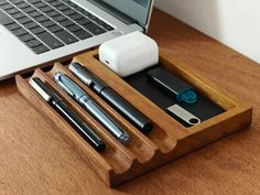 a wooden desk with a laptop and pen holder