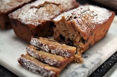 several pieces of cake on a plate with powdered sugar and chocolate chunks around them