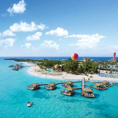 an aerial view of a beach resort and lagoon with boats in the water next to it