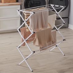 an ironing board with towels on it in front of a washer and dryer