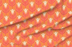 an orange fabric with pink and white leaves on it, as well as the background