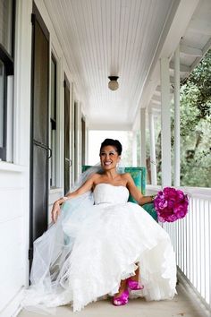 a woman in a wedding dress sitting on a porch with her feet up and flowers in her hand