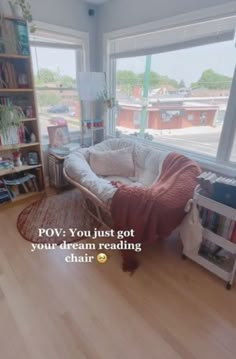 a living room filled with furniture and lots of windows next to a book shelf full of books