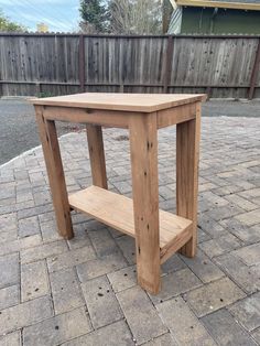 a wooden table sitting on top of a brick patio