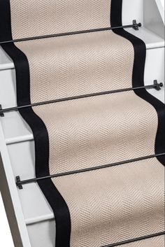 a stair case with black and beige carpet