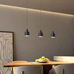 an image of a dining room setting with fruit on the table and hanging lights above