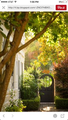 an entrance to a house with trees and bushes