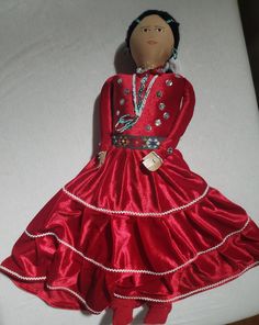 a doll is dressed in a red dress