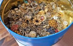 a blue bucket filled with lots of jewelry