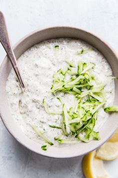 a bowl filled with white oatmeal and garnished with broccoli