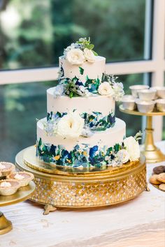 a white and blue wedding cake sitting on top of a table