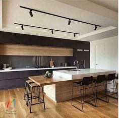 a modern kitchen with an island and bar stools