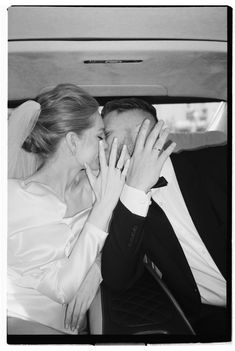 a bride and groom kissing in the back of a car