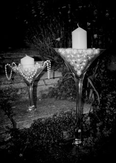 two martini glasses with pearls and a candle