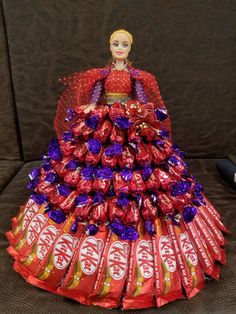 a barbie doll sitting on top of a pile of candy bar wrapped in wrappers