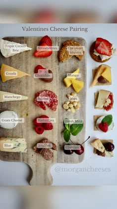 a wooden cutting board topped with different types of cheeses and fruit on top of each other