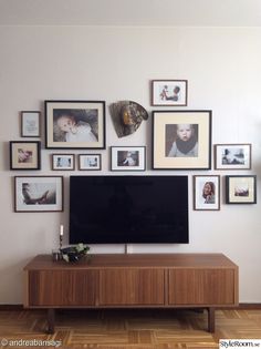 a flat screen tv sitting on top of a wooden entertainment center in a living room