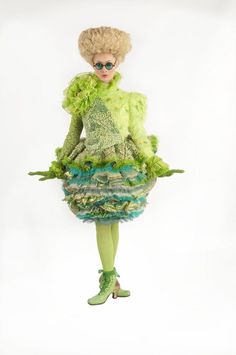 a mannequin dressed in green and blue clothing, with sunglasses on her head