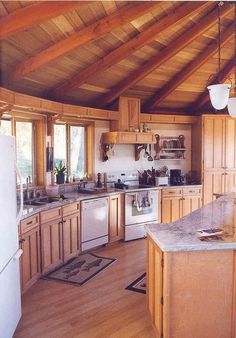 a large kitchen with wooden cabinets and white refrigerator freezer next to a stove top oven