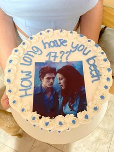 a person holding a cake with an image of two people on it and the words how long have you been?