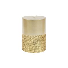 a candle that is sitting in front of a white background with gold glitter on it