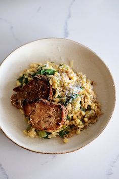 a white bowl filled with food on top of a table