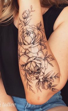 a woman with a black and white rose tattoo on her arm