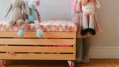 two stuffed animals sitting on top of a wooden crate