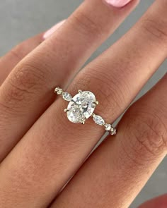 a woman's hand with a diamond ring on top of her finger and the bottom half