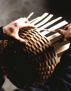 a person holding a basket made out of wood